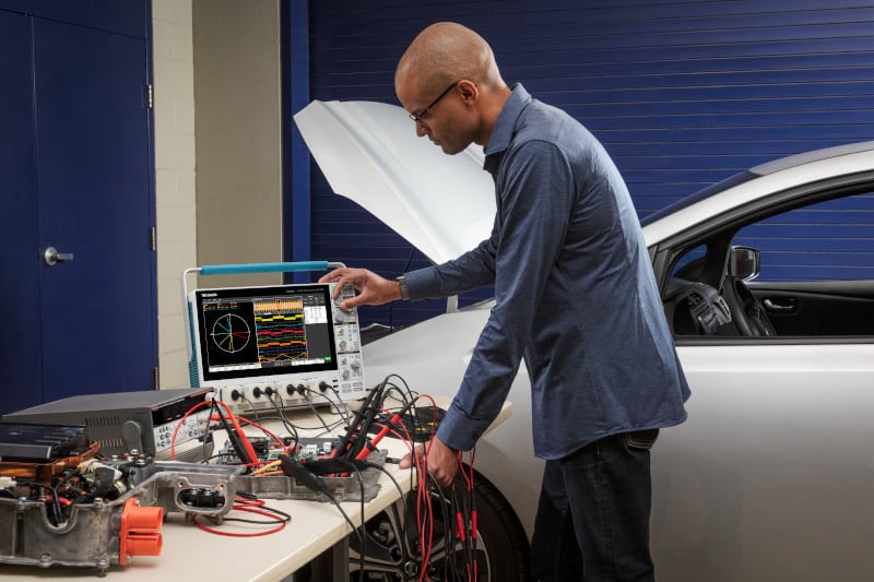 Engineer using a 4 Series B MSO oscilloscope with motor drive analysis software to analyze the 3-phase output of a motor drive used in an electric vehicle