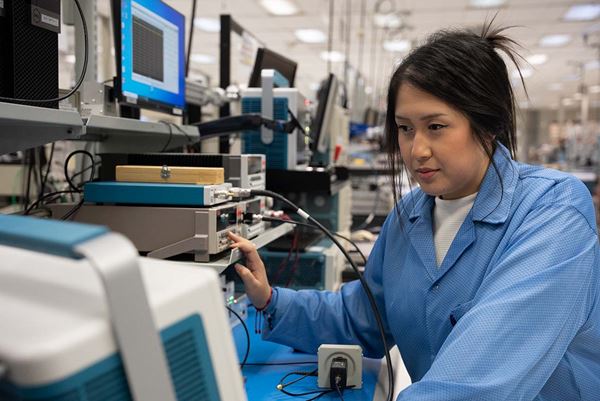 女技术服务人员在工程实验室操作测试和测量设备。